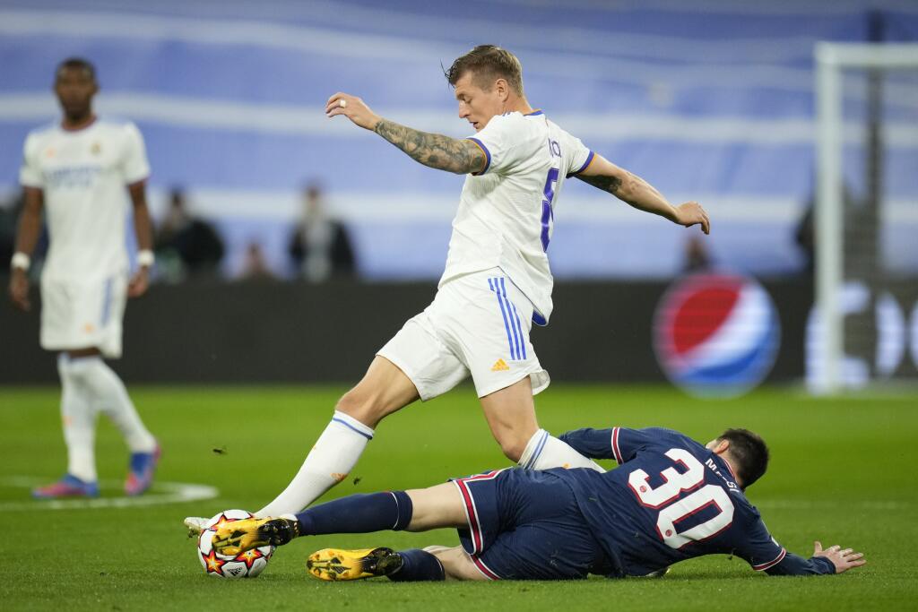 Na snímke vpravo dole hráč PSG Lionel Messi, vľavo hráč Madridu Toni Kroos v odvete osemfinále Ligy majstrov vo futbale Real Madrid - Paríž Saint Germain v Madride 9. marca 2022. FOTO TASR/AP