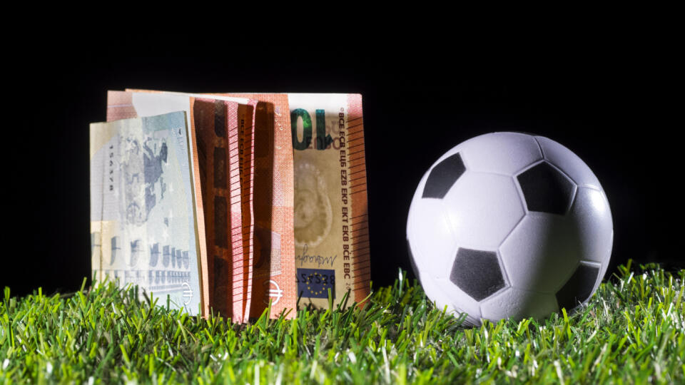 Ball of football on the lawn and a heap of tickets of Euro, business concept in the football