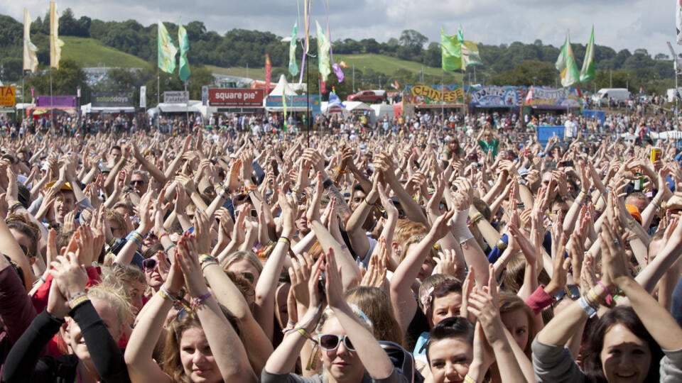 Hudobní fanúšikovia tlieskajú na hudobnom festivale v anglickom Glastonbury.