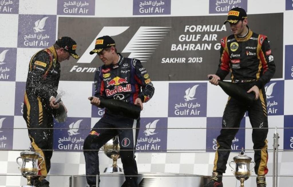Red Bull driver Sebastian Vettel of Germany, winner, center, second place Lotus driver Kimi Raikkonen of Finland, left, and Lotus driver Romain Grosjean of France spray rose water in lieu of champagne on the podium after the Bahrain Formula One Grand Prix in Sakhir, Bahrain, Sunday, April 21, 2013. (AP Photo/Hassan Ammar)