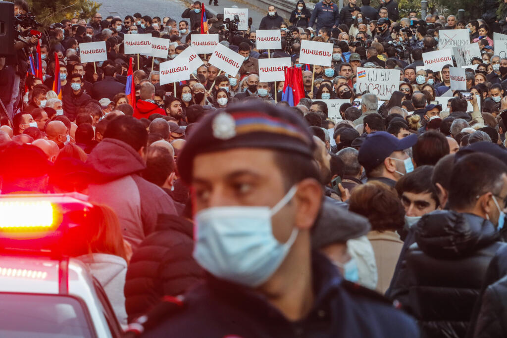 JB 20 Jerevan - Policajt hliadkuje na ulici, zatiaľčo demonštranti sa zhromažďujú počas protestu proti podpísaniu vyhlásenia o prímerí medzi arménskymi a azerbajdžanskými vojenskými jednotkami v samozvanom regióne Náhorný Karabach v Jerevane 12. novembra 2020. V Arménsku zadržali vo štvrtok desať popredných predstaviteľov opozície za podiel na násilných nepokojoch. Tie v krajine vypukli po tom, čo arménsky premiér Nikol Pašinjan podpísal dohodu s Azerbajdžanom týkajúcu sa ukončenia bojov v Náhor