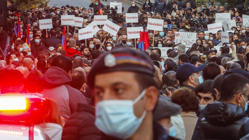 JB 20 Jerevan - Policajt hliadkuje na ulici, zatiaľčo demonštranti sa zhromažďujú počas protestu proti podpísaniu vyhlásenia o prímerí medzi arménskymi a azerbajdžanskými vojenskými jednotkami v samozvanom regióne Náhorný Karabach v Jerevane 12. novembra 2020. V Arménsku zadržali vo štvrtok desať popredných predstaviteľov opozície za podiel na násilných nepokojoch. Tie v krajine vypukli po tom, čo arménsky premiér Nikol Pašinjan podpísal dohodu s Azerbajdžanom týkajúcu sa ukončenia bojov v Náhor