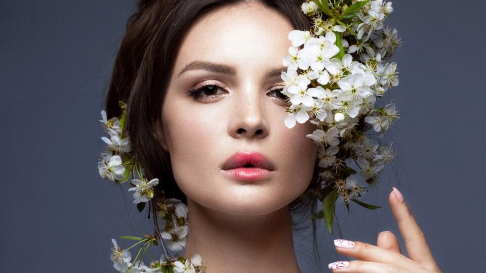 Beautiful girl  with gentle romantic make-up, pink lips and flowers