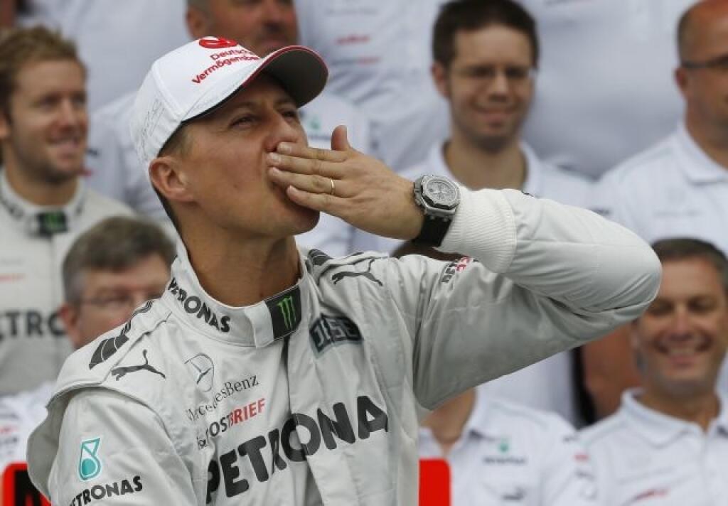 Mercedes Grand Prix driver Michael Schumacher of Germany kisses his hand during an official team photo before the Fromula One Brazilian Grand Prix at the Interlagos race track in Sao Paulo, Brazil, Sunday, Nov. 25, 2012. Seven-time world champion Schumacher will be retiring for the second time after the race. (AP Photo/Silvia Izquierdo)