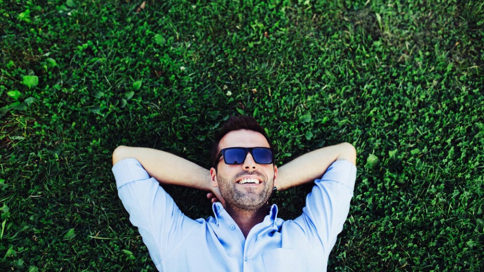 Portrait,Of,A,Young,Happy,Man,Relaxing,On,The,Grass