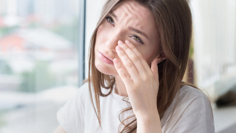 Young,Sad,Woman,Sits,Alone,Front,Of,The,Window.,Crying