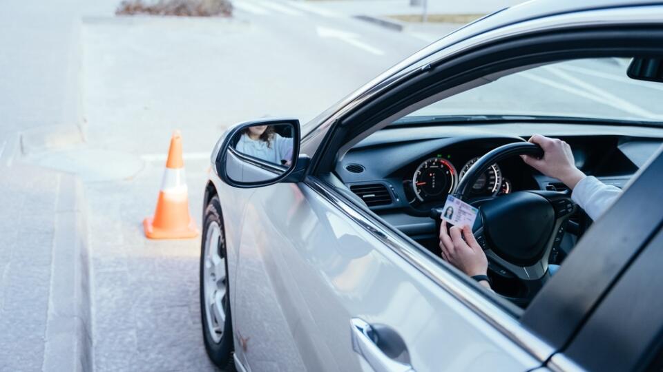 Close,Up,Of,Womand,Hands,On,Wheel,With,Driving,License.