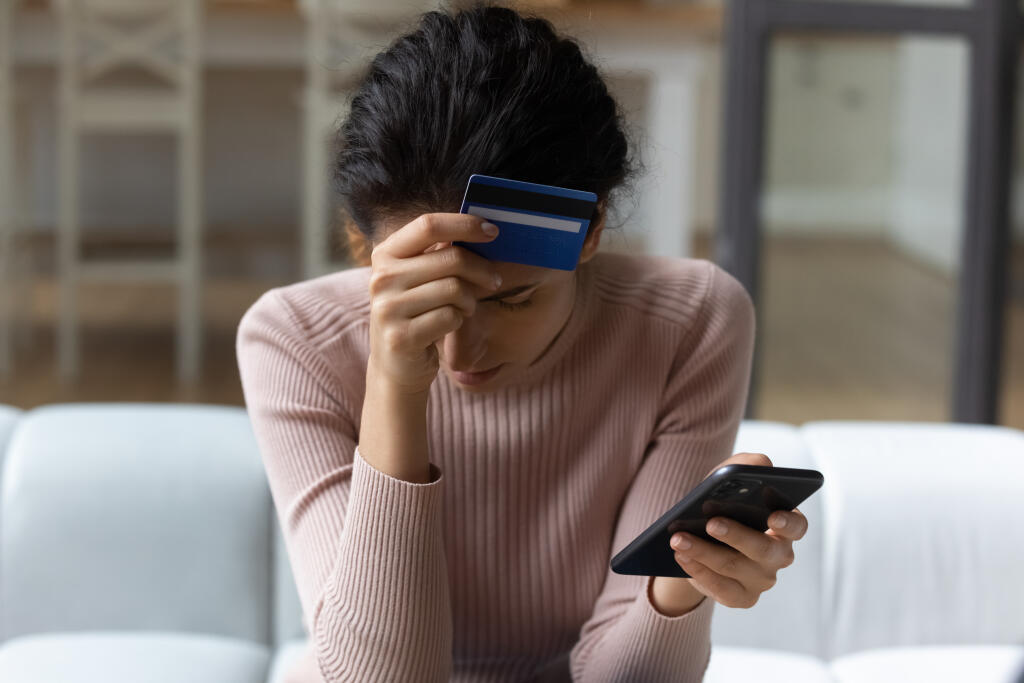 Upset,Latina,Female,Internet,Shopper,Sit,On,Couch,Hold,Phone
