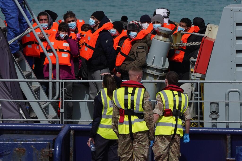 Skupina ľudí považovaná za migrantov vystupuje z plavidla pobrežnej záchrannej služby RNLI po nehode malej lode v Doveri na juhovýchode Anglicka v stredu 13. apríla 2022. Britské vojenské námorníctvo bude hliadkovať v Lamanšskom prielive, aby zachytilo ilegálnych migrantov snažiacich sa preplávať z Francúzska do Spojeného kráľovstva.