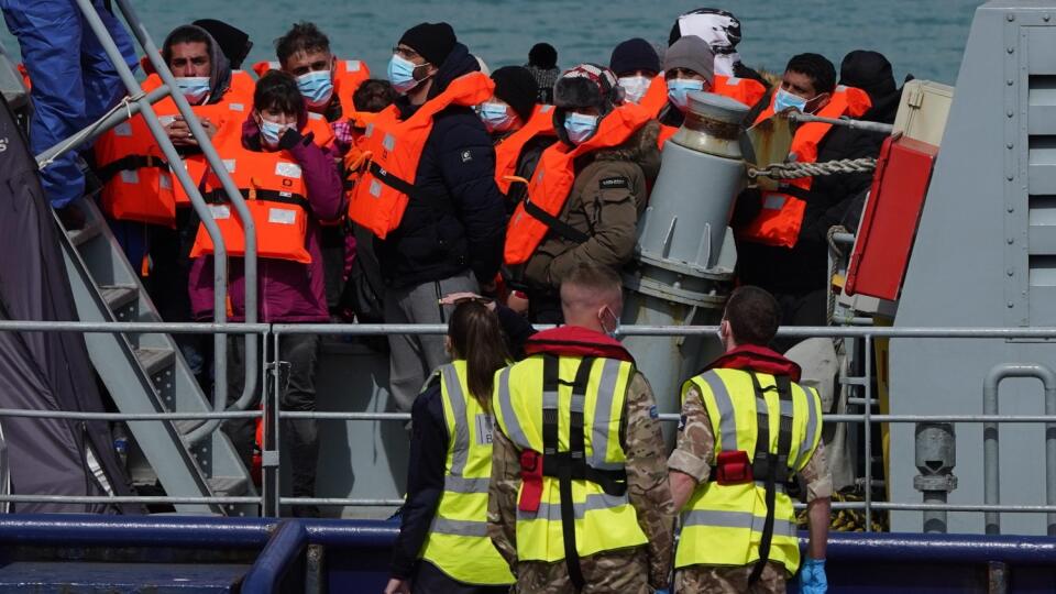Skupina ľudí považovaná za migrantov vystupuje z plavidla pobrežnej záchrannej služby RNLI po nehode malej lode v Doveri na juhovýchode Anglicka v stredu 13. apríla 2022. Britské vojenské námorníctvo bude hliadkovať v Lamanšskom prielive, aby zachytilo ilegálnych migrantov snažiacich sa preplávať z Francúzska do Spojeného kráľovstva.