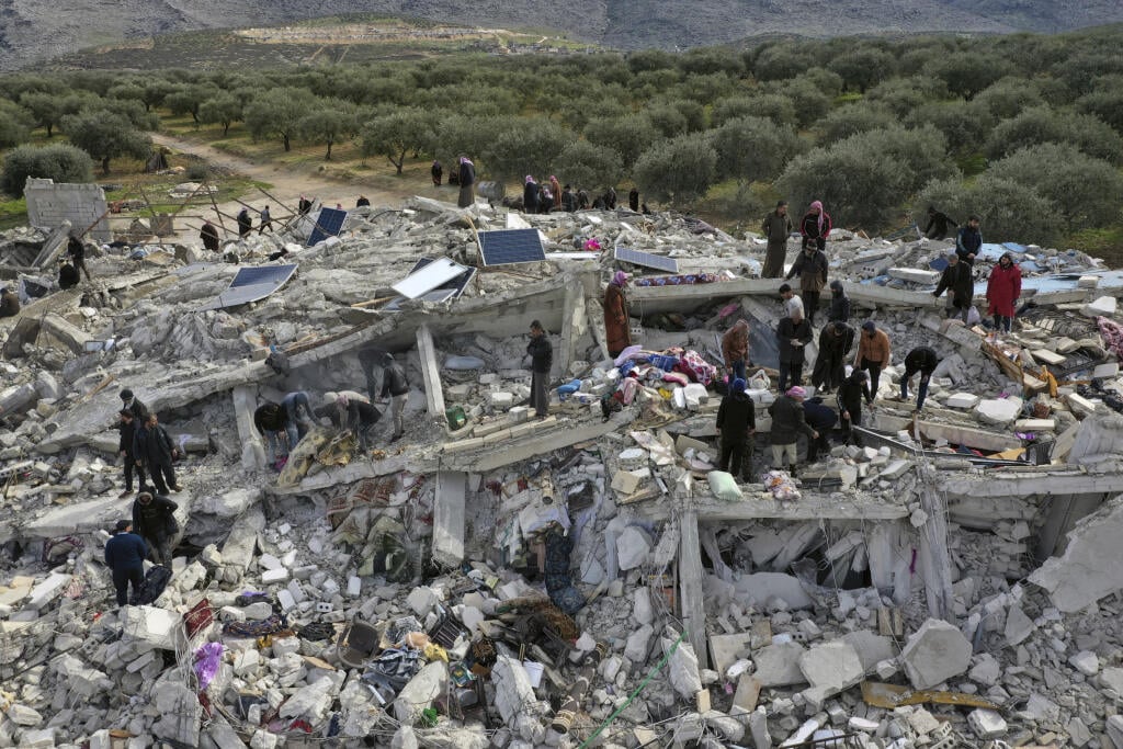 KK3 Harem - Pracovníci civilnej obrany a obyvatelia prehľadávajú ruiny zrútených budov v meste Harem pri tureckých hraniciach v sýrskej provincii Idlib 6. februára 2023. Najmenej 195 ľudí prišlo o život v noci na pondelok pri silnom zemetrasení, ktoré nastalo na juhovýchode Turecka neďaleko hranice so Sýriou. Otrasy s magnitúdou 7,8 zničili mnohé budovy na oboch stranách hranice a vystrašení obyvatelia vybiehali do zasnežených ulíc počas studenej zimnej noci. FOTO TASR/AP
Civil defense workers a