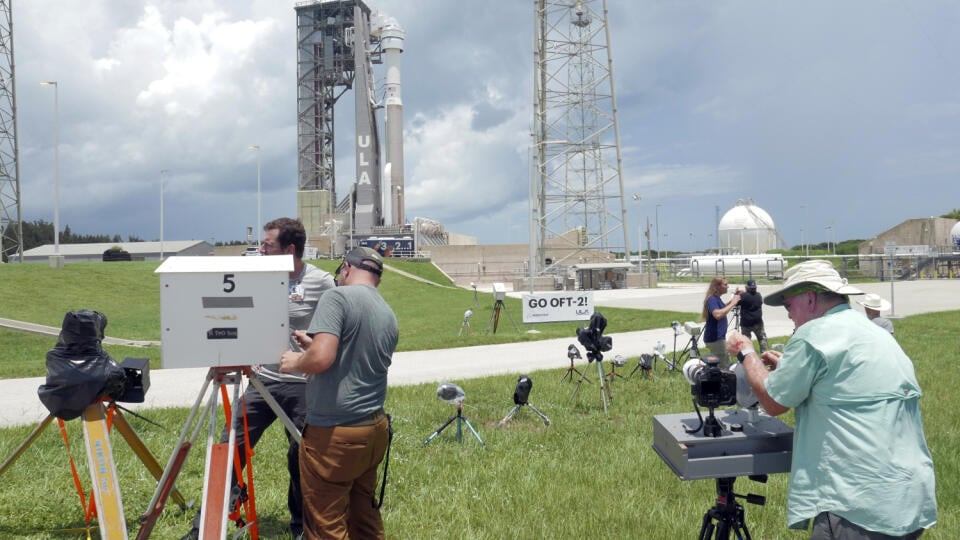 Fotografi stoja pred raketou Atlas V na štartovacej rampe pred štartom z Kennedyho vesmírneho strediska na Myse Kanaveral na Floride
2. augusta 2021. Raketa poletí v utorok na Medzinárodnú vesmírnu stanicu s kozmickou loďou Starliner spoločnosti Boeing.