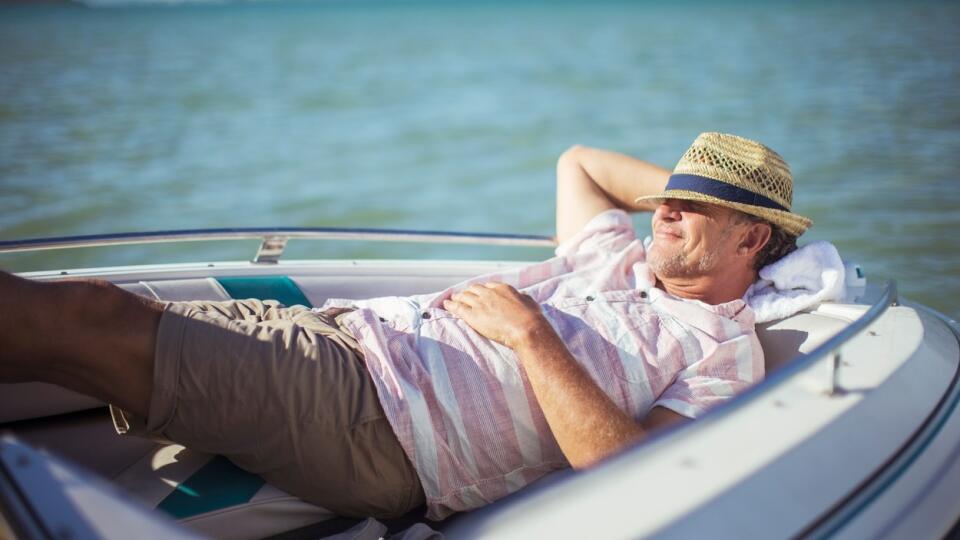 Older man relaxing in boat on water