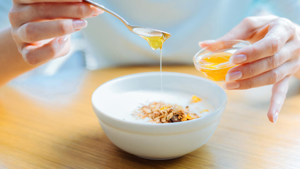 Close,Up,Of,Female,Hands,Adding,Honey,To,Oatmeal