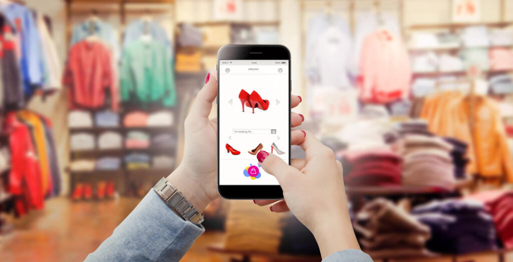 Woman,In,Clothing,Store,Holding,Phone,In,Hands,And,Searching