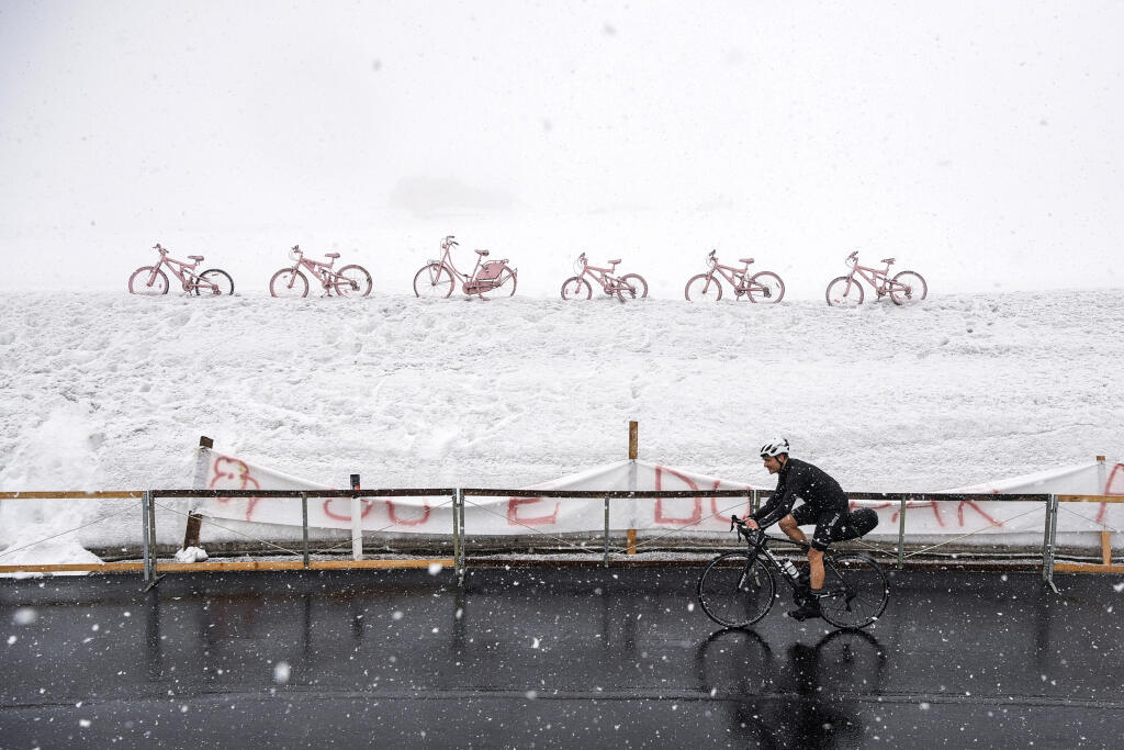 Osamotený cyklista prechádza počas sneženia cez horský priesmyk Giau v Dolomitoch počas 16. etapy cyklistických pretekov Giro d'Italia