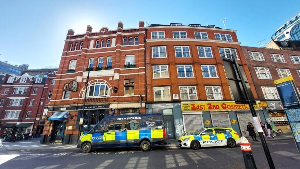 LONDON, UK-18 MAR 25: City police van and police car parking in front of brick old building near Liverpool Street in East London United Kingdom