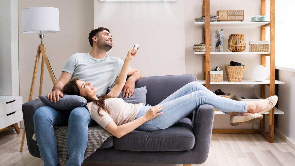 Happy,Woman,Holding,Air,Conditioner,Remote,Control