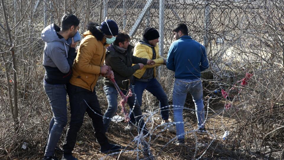 EBE 9 Pazarakule - Na snímke migranti sa pokúšajú prestrihnúť oplotenie na turecko-gréckej hranici v blízkosti hraničnej brány Pazarkule v tureckom meste Edirne 2. marca 2020. FOTO TASR/AP
Migrants try to cut the fence at the Turkish-Greek border near the Pazarkule border gate in Edirne, Turkey on Monday, March 2, 2020.Thousands of migrants and refugees massed at Turkey's western frontier Sunday, trying to enter Greece by land and sea after Turkey said its borders were open to those hoping to he