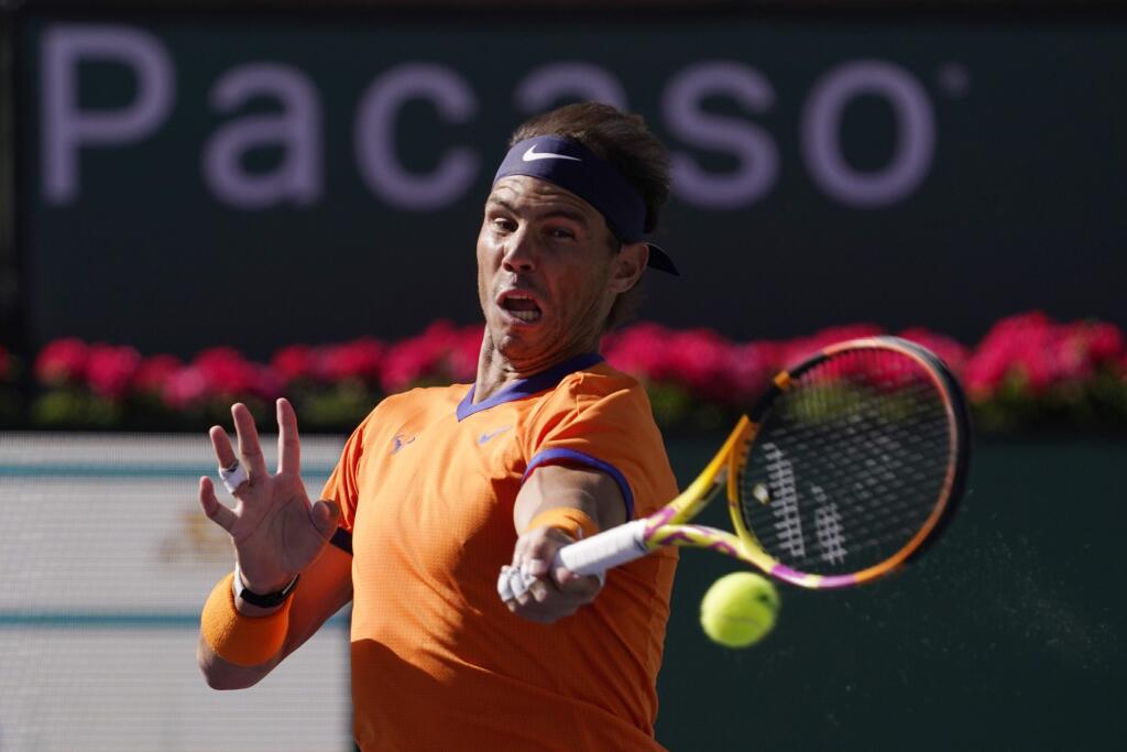 Na snímke Španiel Rafael Nadal odvracia úder Američana Taylora Fritza vo finále dvojhry mužov na turnaji ATP Masters 1000 v Indian Wells v nedeľu 20. marca 2022. Nadal prehral s domácim Američanom Taylorom Fritzom za 127 minút 3:6, 6:7 (5).