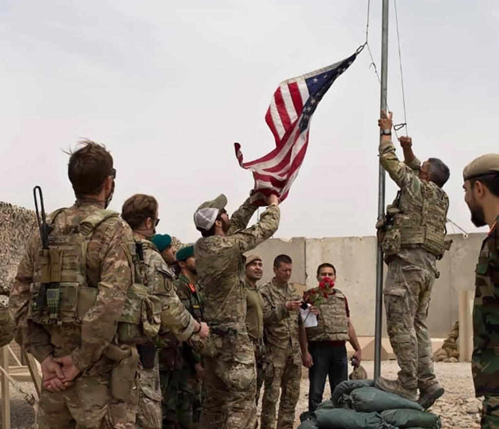 Spúšťanie americkej vlajky v provincii Helmand na juhu Afganistanu 2. mája 2021. Americkí vojaci zároveň odovzdali techniku afganským bezpečnostným zložkám.