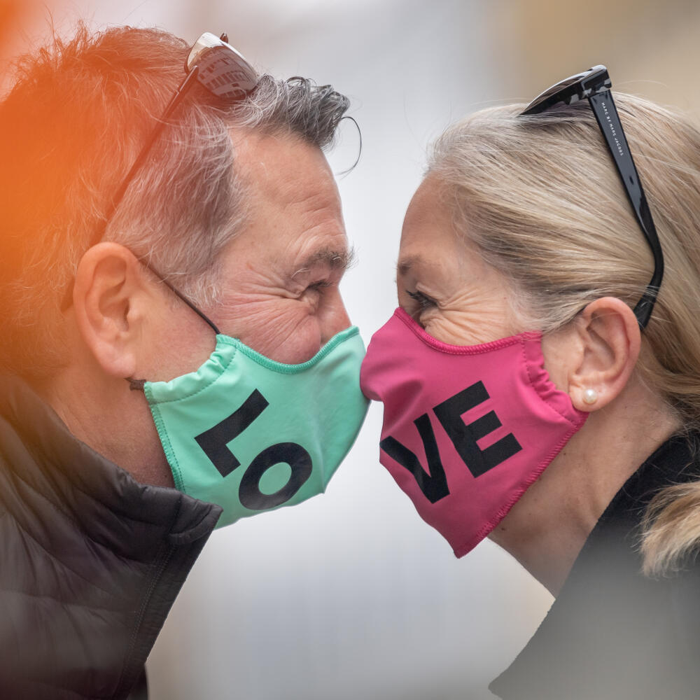 WA 36 Mníchov - Jörg a Petra s ochrannými rúškami, ktoré vytvárajú slovo láska, sa zdravia nosmi počas stretnutia v Mníchove v pondelok 27. apríla 2020. Viaceré štáty sveta, vrátane Nemecka, uvoľnili od pondelka niektoré opatrenia proti šíreniu koronavírusu. Od tohto týždňa bude možné v nemeckej spolkovej krajine Bavorsko za určitých podmienok znova otvoriť obchody do 800 metrov štvorcových. V obchodoch a mestskej hromadnej doprave musia ľudia nosiť rúško alebo inú ochranu nosa a úst. FOTO TASR/