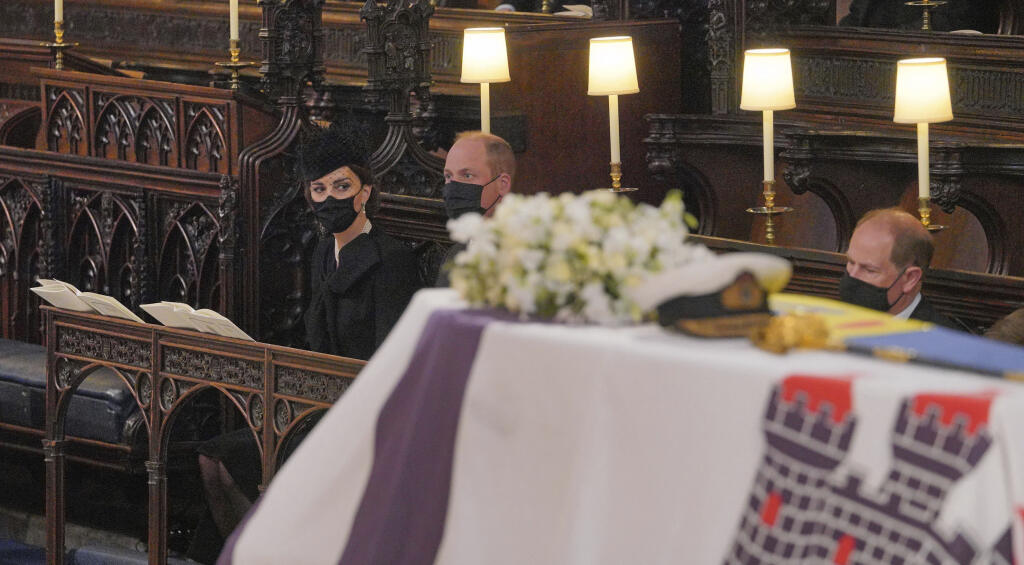 Členovia kráľovskej rodiny zľava Kate, vojvodkyňa z Cambridgeu, princ William a princ Edward sa pozerajú neďaleko rakvy s telesnými pozostatkami britského princa Philipa v Kaplnke svätého Juraja počas pohrebu britského princa Philipa.