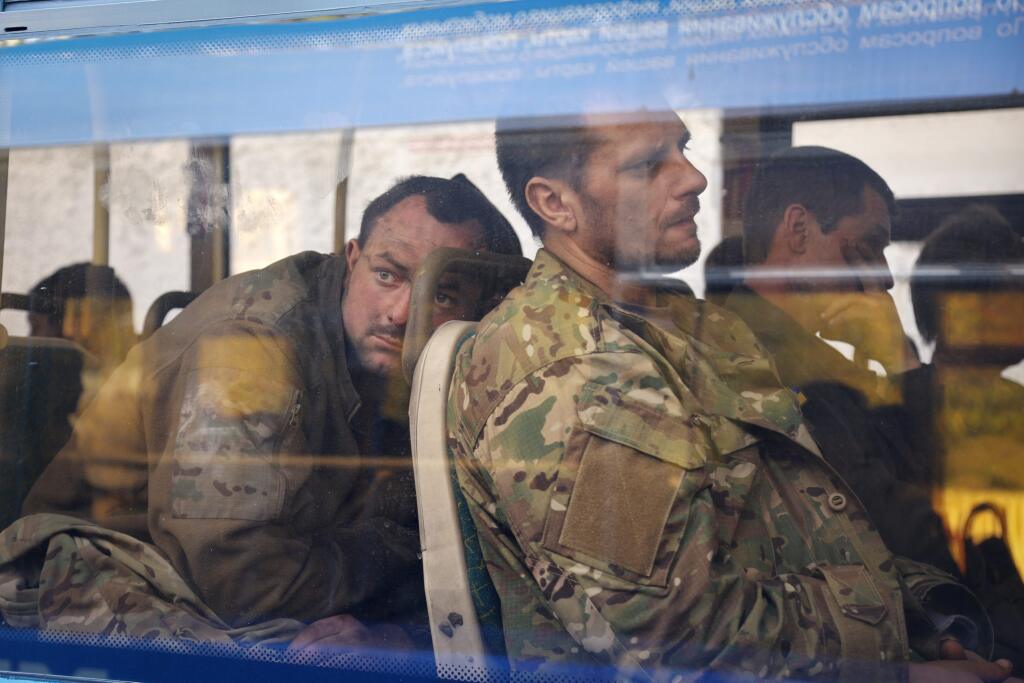 WA 18 Olenivka - Ukrajinskí vojaci, ktorí niekoľko týždňov odolávali útokom ruských síl v oceliarniach Azovstaľ v prístavnom meste Mariupol, sedia v autobuse po evakuácii neďaleko väznice v obci Olenivka v Doneckej oblasti na východe Ukrajiny v utorok 17. mája 2022. Sedem autobusov s ukrajinskými vojakmi údajne previezli do obcí v Donecku ovládaných Ruskom. Námestníčka ukrajinského ministra obrany Hanna Maľarová neskôr povedala, že Kyjev pozná počet ukrajinských vojakov, ktorí sa ešte nachádzajú