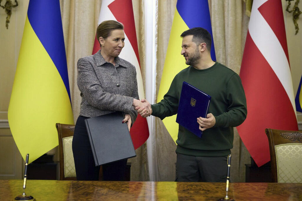 Ukrajinský prezident Volodymyr Zelenskyj a dánska premiérka Mette Frederiksen si podávajú ruky po podpise dokumentov v Ľvove na Ukrajine.
