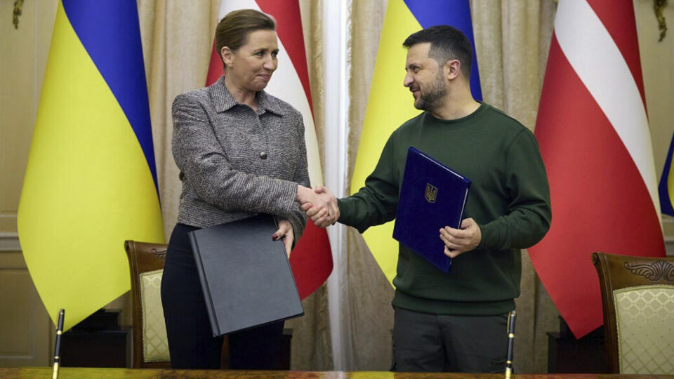 Ukrajinský prezident Volodymyr Zelenskyj a dánska premiérka Mette Frederiksen si podávajú ruky po podpise dokumentov v Ľvove na Ukrajine.