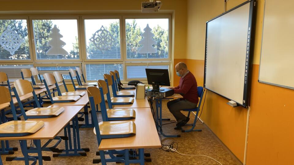 Učiteľ dejepisu počas dištančnej výučby v prázdnej triede.