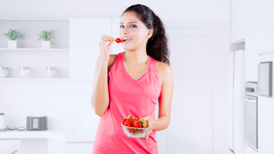 Indian,Woman,Tasting,Strawberry,While,Preparing,Salad,In,A,Luxury