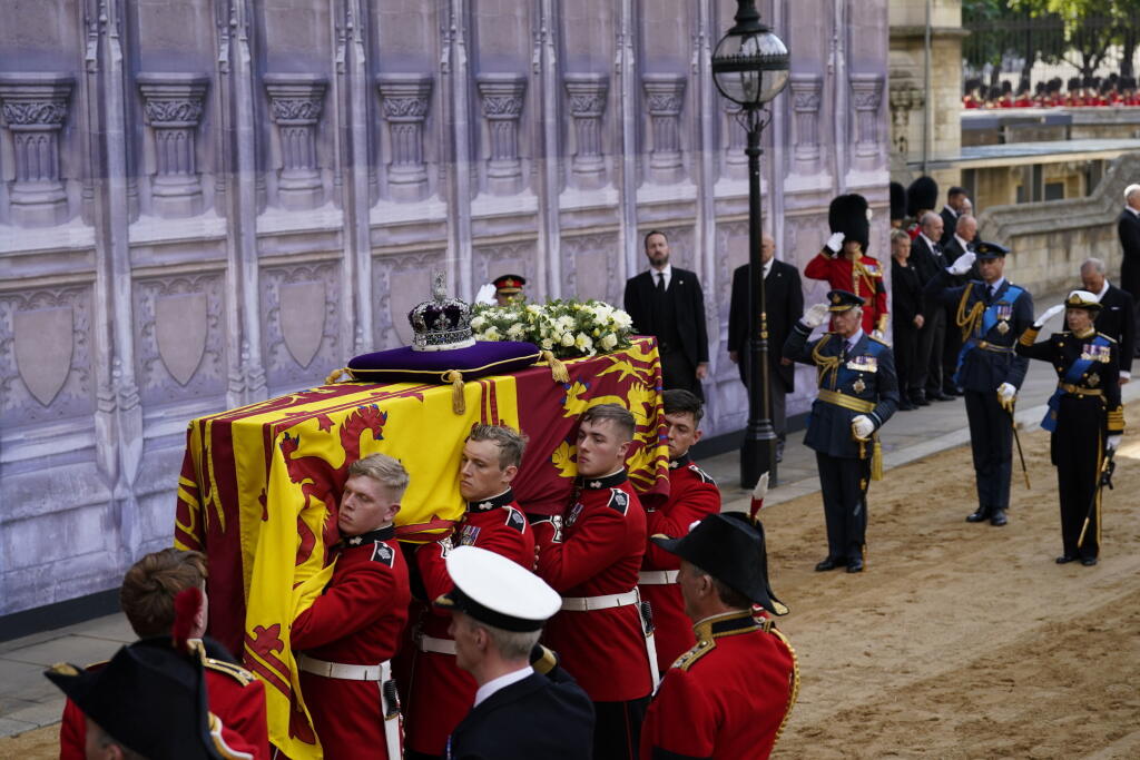 Britský kráľ Karol III., britská princezná Anna a britský princ William, princ z Walesu salutujú pri rakve s telesnými pozostatkami zosnulej britskej kráľovnej Alžbety II. po jej príchode do Westminsterského paláca v Londýne 14. septembra 2022.