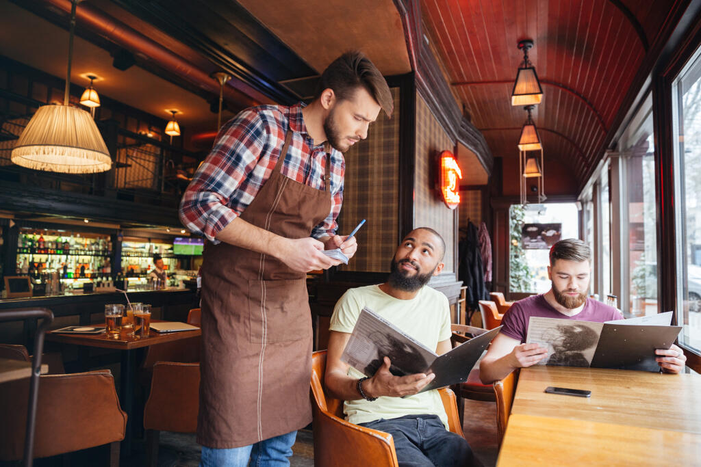Serious,Concentrated,Young,Waiter,Standing,And,Taking,An,Order,From