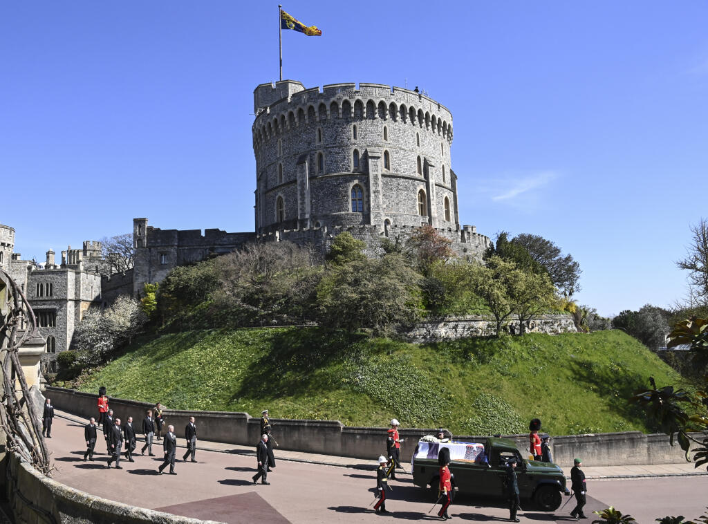 JB 84 Windsor - Členovia kráľovskej rodiny zľava britský princ Charles, princezná Anne, princ Andrew. princ Edward, princ William, Peter Phillips, princ Harry a Tim Laurence sprevádzajú rakvu pri prechádzaní okolo veže Round Tower počas pohrebu britského princa Philipa, manžela britskej kráľovnej Alžbety II., ktorý zomrel minulý piatok vo veku 99 rokov, v areáli Windsorského zámku vo Windsore 17. apríla 2021. Philipovo telo previezli zo súkromnej kaplnky pred vchod hradného areálu na špeciálne u