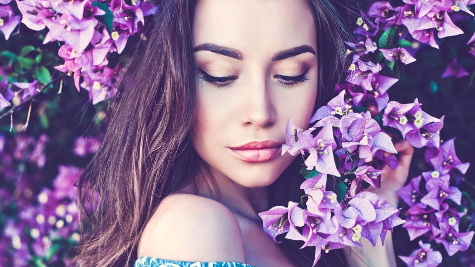 Beautiful young woman surrounded by flowers