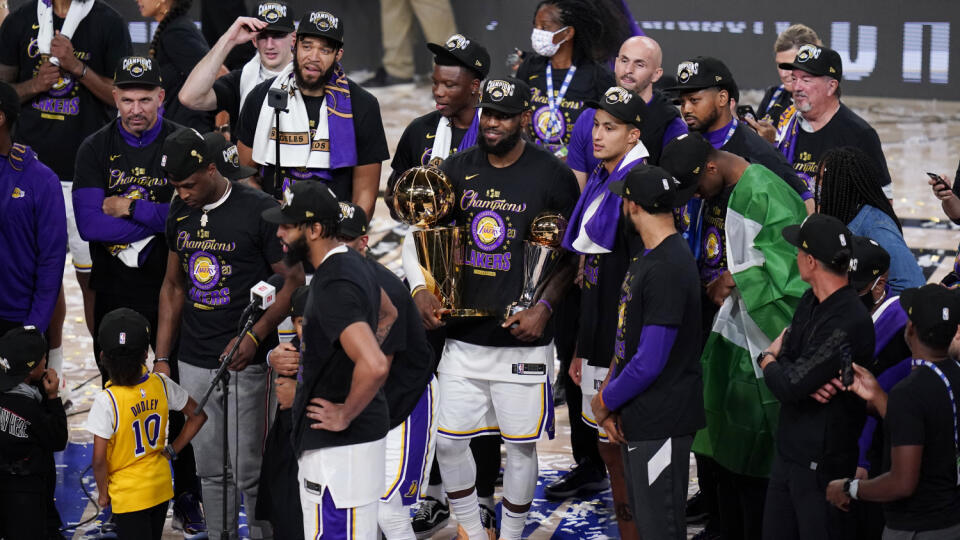 Na snímke uprostred hráč Los Angeles Lakers LeBron James s pohárovými trofejami oslavuje titul šampióna NBA v ročníku 2019/2020. V šiestom stretnutí finálovej série v noci na 12. októbra 2020 zdolali Lakers Miami Heat hladko 106:93 a v sérii triumfovali 4:2 na zápasy. Lakers získali 17. titul a v historickej tabuľke sa posunuli na prvé miesto, kde sú zhodne s Bostonom Celtics.