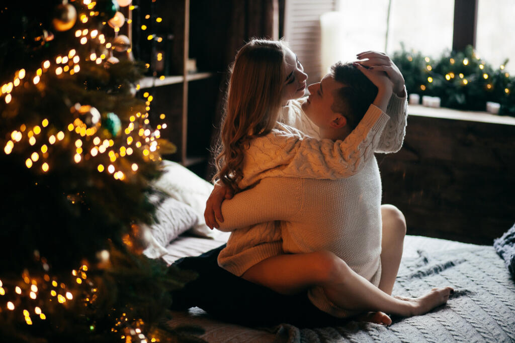 Couple,In,Love,Near,The,Christmas,Tree,On,The,Bed