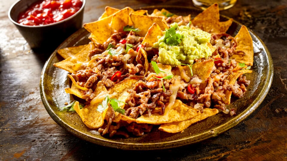 Yellow,Corn,Nacho,Chips,Garnished,With,Ground,Beef,,Guacamole,,Melted