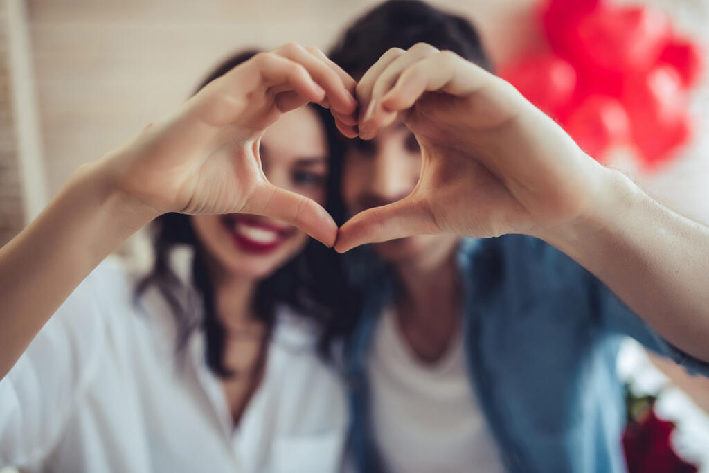 Beautiful,Young,Couple,At,Home,Is,Making,Heart,Sign,With