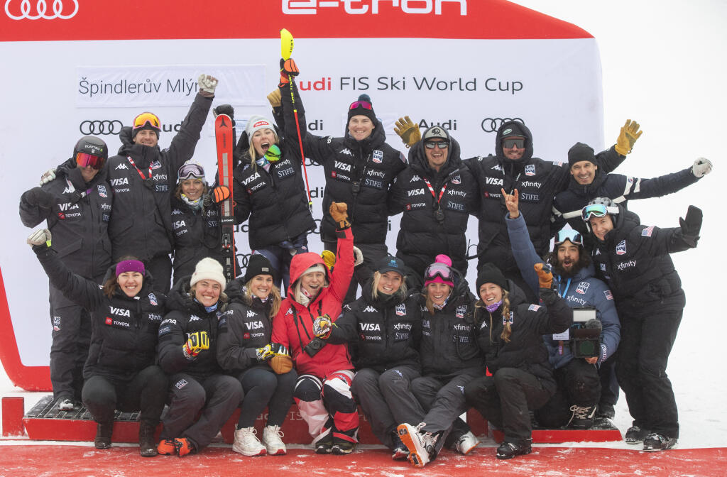 Na snímke uprostred americká lyžiarka Mikaela Shiffrinová a jej tím oslavujú na pódiu po 2. kole slalomu žien Svetového pohára v alpskom lyžovaní v českom Špindlerovom Mlyne v nedeľu 29. januára 2023. Slovenská lyžiarka Petra Vlhová obsadila 13. miesto. FOTO TASR - Martin Baumann