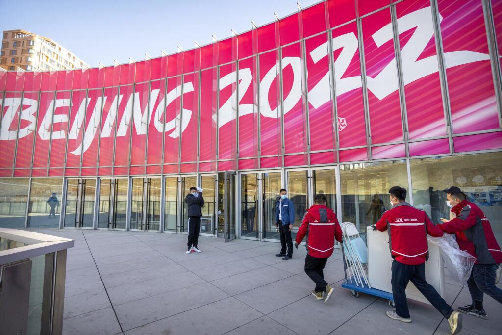 WA 31 Peking - Pracovníci tlačia vozík v olympijskej dedine zimných olympijských a paralympijských hier v Pekingu v piatok 24. decembra 2021. V poradí XXIV. zimné olympijské hry sa v Pekingu uskutočnia od 4. do 20. februára 2022. Paralympijské hry prídu na rad  od 4. do 13. marca. FOTO TASR/AP