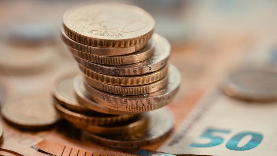 Pile,Of,Euro,Coins,On,Euro,Notes.