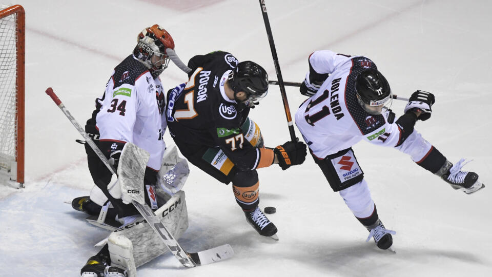 Na snímke uprostred Patrik Rogoň (Košice), vľavo brankár Filip Belányi, vpravo jeho spoluhráč Matúš Holenda (obaja HC‘05 Banská Bystrica) v zápase 33. kola hokejovej Tipos extraligy HC Košice - HC‘05 Banská Bystrica 27. januára 2023 v Košiciach. FOTO TASR - František Iván 