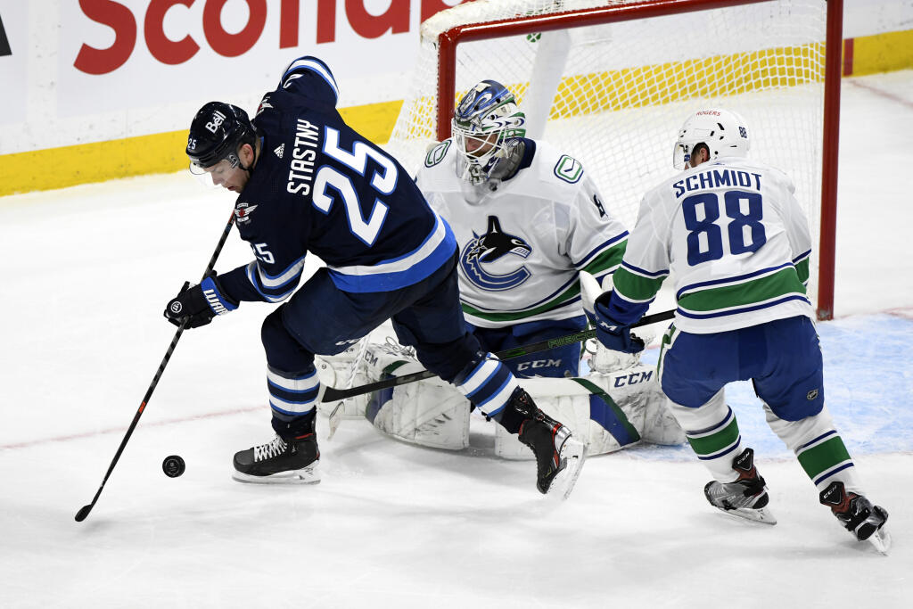 WA 33 Winnipeg - Hokejista Winnipegu Jets Paul Šťastný (vľavo), brankár Vancouveru Canucks Braden Holtby (uprostred) a hráč Vancouveru Nate Schmindt (vpravo) počas zápasu zámorskej hokejovej NHL Winnipeg Jets - Vancouver Canucks vo Winnipegu v utorok 11. mája 2021. Winnipeg triumfoval na vlastnom ľade nad Vancouverom 5:0 a útočník Winnipegu Paul Šťastný odohral jubilejný 1000. duel v základnej časti NHL. FOTO TASR/AP
Winnipeg Jets' Paul Stastny (25) tries to control the puck in front of Van