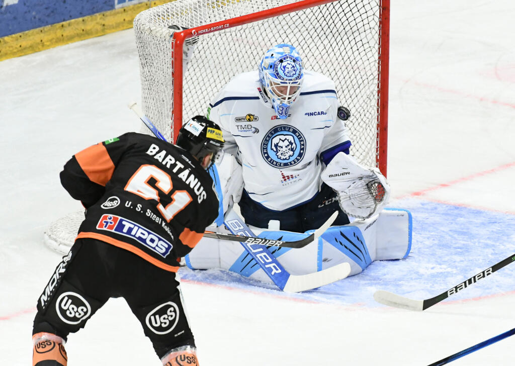Na snímke Marek Bartánus (Košice) dáva úvodný gól brankárovi Davidovi Honzíkovi (Nitra) v zápase 1. kola hokejovej Tipos extraligy medzi HK Nitra a HC Košice 24. septembra 2021 v Nitre. FOTO TASR - Henrich Mišovič