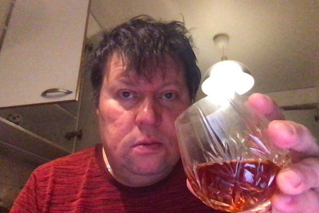 Dominikin manžel sa fotil, ako pije alkohol.