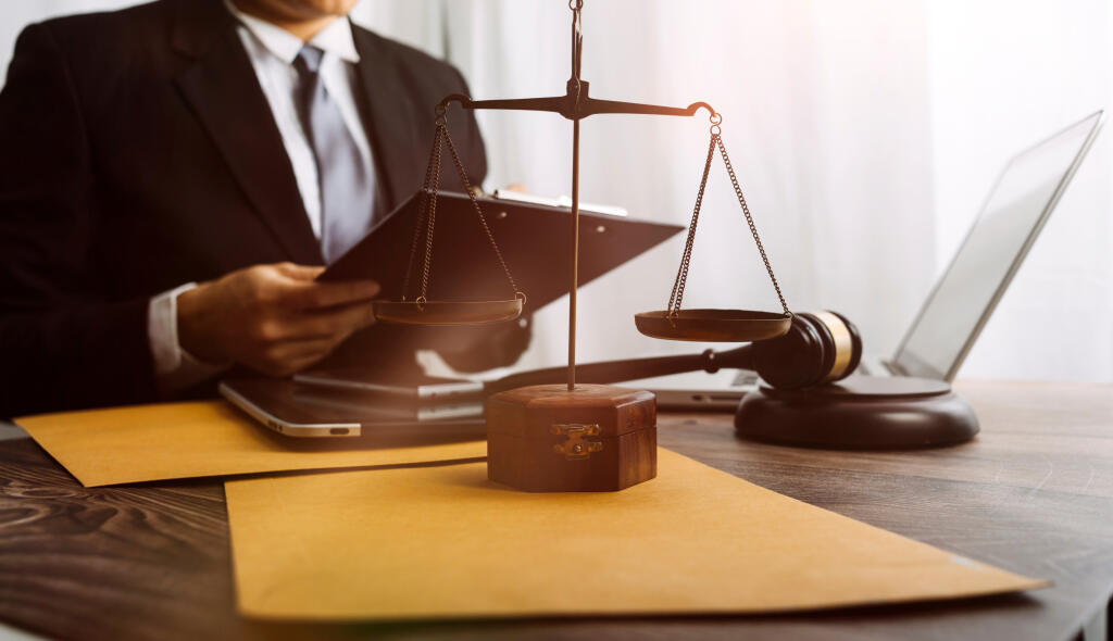 Business and lawyers discussing contract papers with brass scale on desk in office. Law, legal services, advice, justice and law concept picture with film grain effect