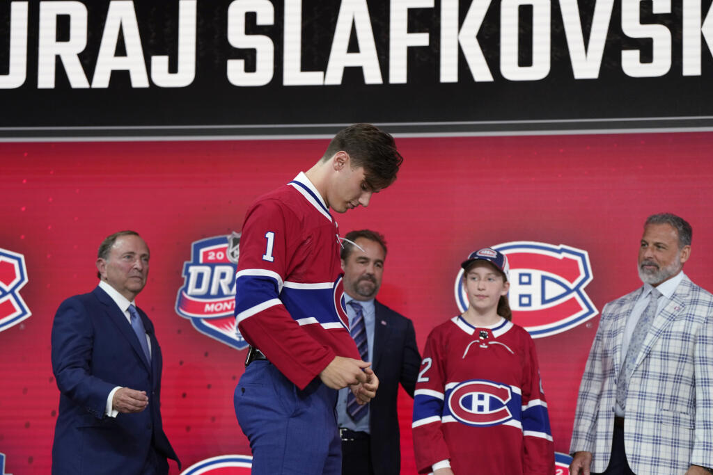 Na snímke slovenský hokejista Juraj Slafkovský si oblieka dres klubu Montreal Canadiens po tom, ako sa stal historicky prvým Slovákom, ktorého si kluby zámorskej hokejovej NHL vybrali z prvého miesta draftu. V noci na piatok 8. júla 2022 po ňom siahol z najvyššej pozície Montreal Canadiens. Osemnásťročný krídelník tak prekonal doterajší rekord Mariána Gáboríka, ktorého si v roku 2000 vybrala z prvého miesta Minnesota Wild.