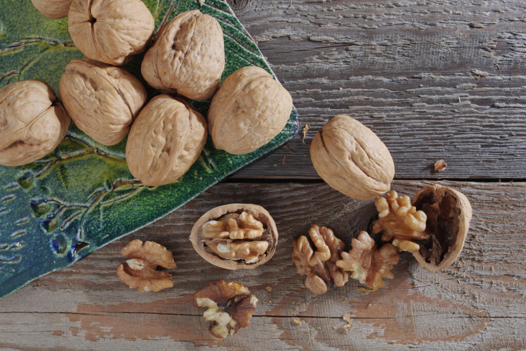 Whole,And,Cracked,Walnuts,On,Ceramic,Cutting,Board,On,Old